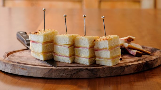 Rezeptidee, Gericht mit Käse Croque Monsieur, angerichtet auf einem Holzbrett